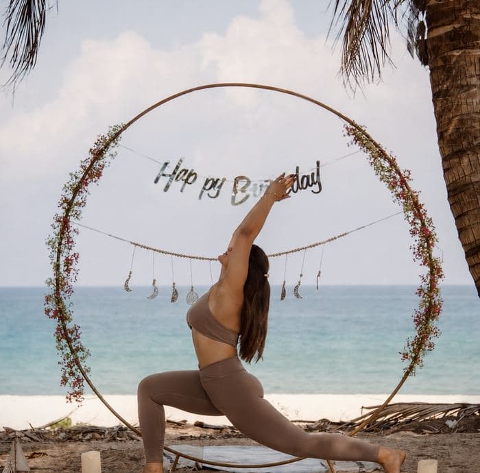 A birthday flower arch on the sand facing the sea