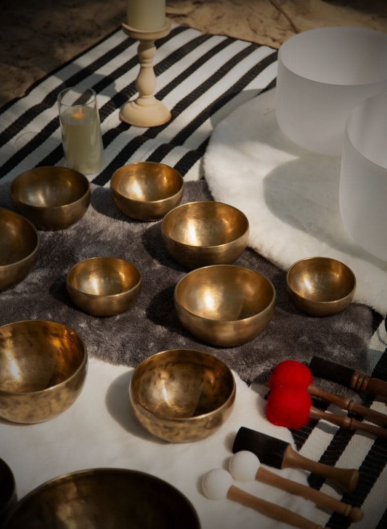 Singing bowls and candles laid out for a sound healing ceremony